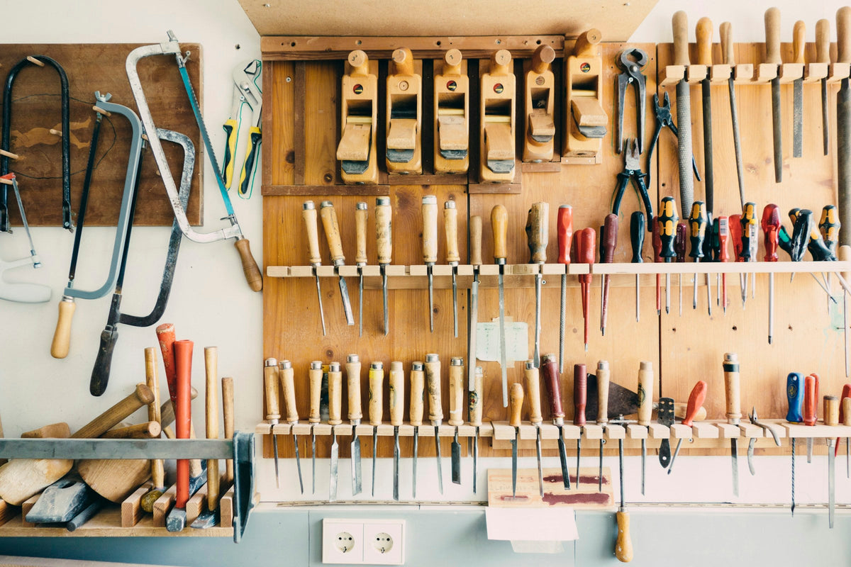 Hand tools hanging in order on a workshop wall